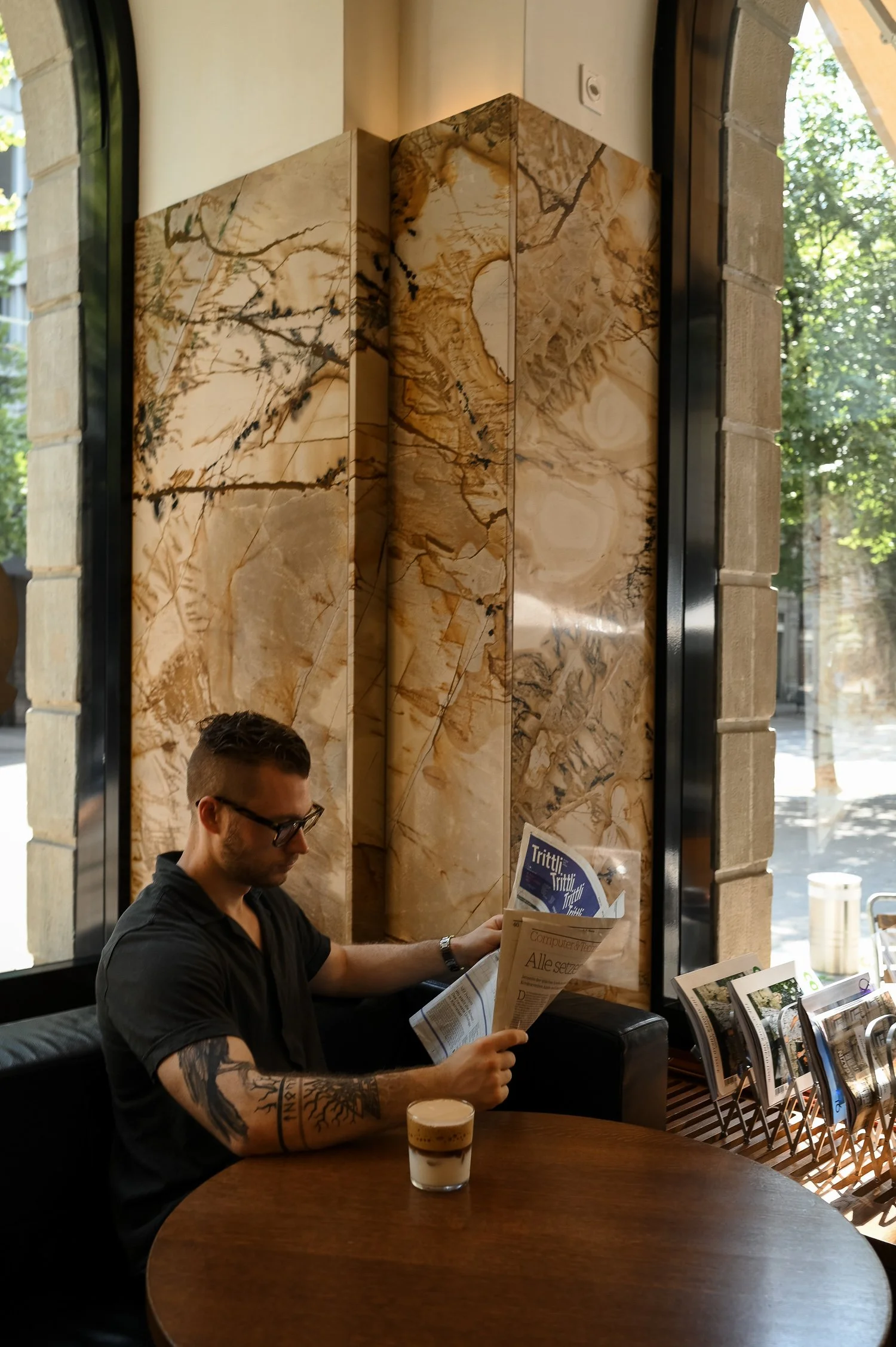 man reading newspaper at cafe