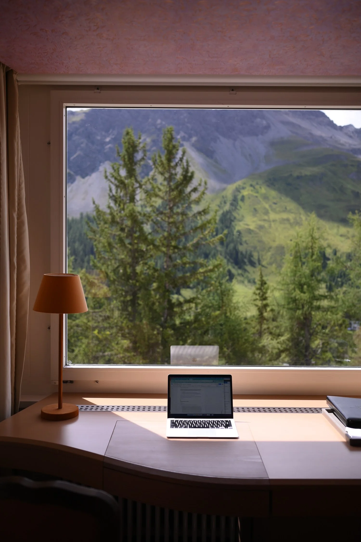 Laptop on a table with a mountains view