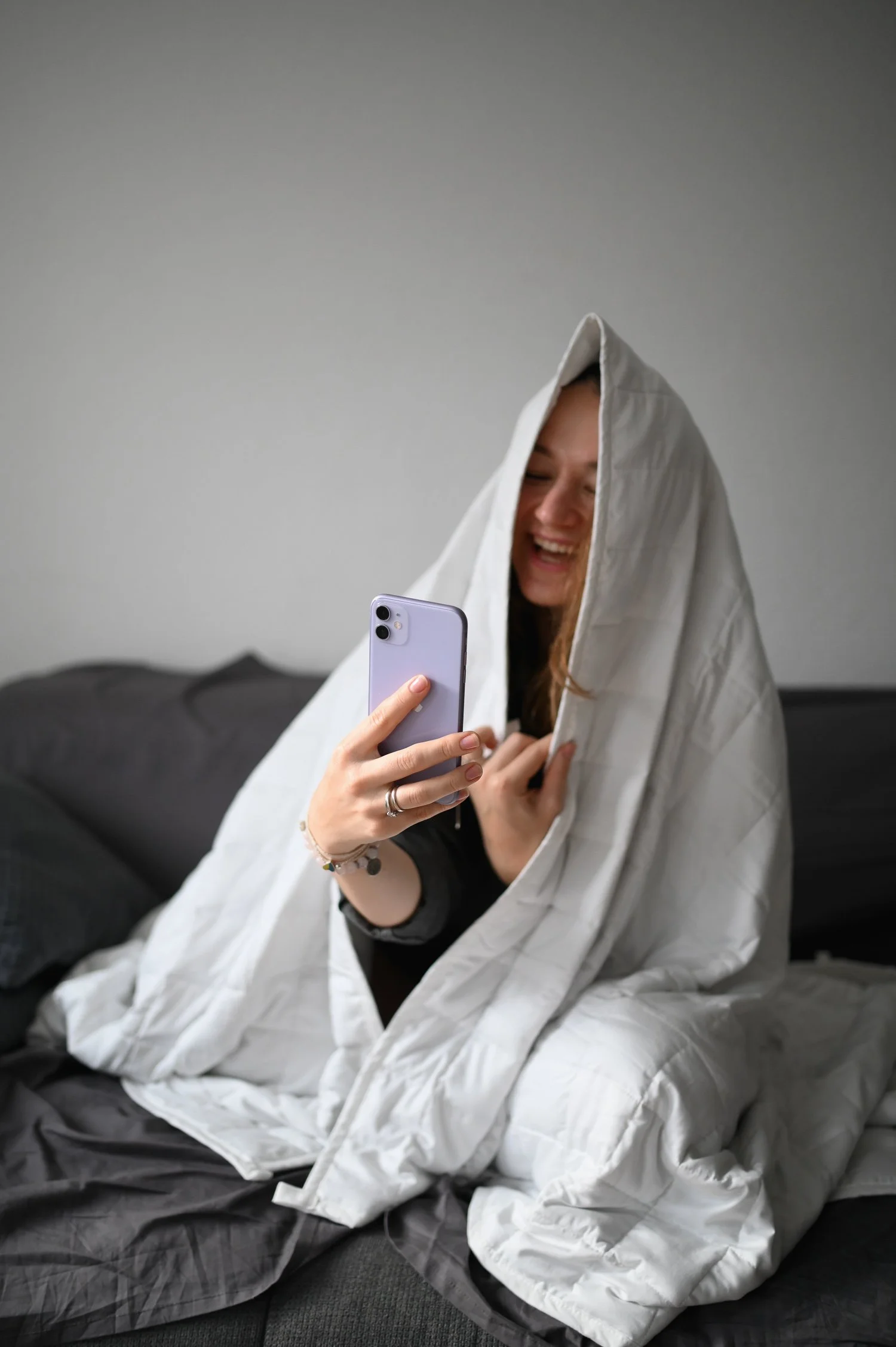 girl with telephone under the blanket