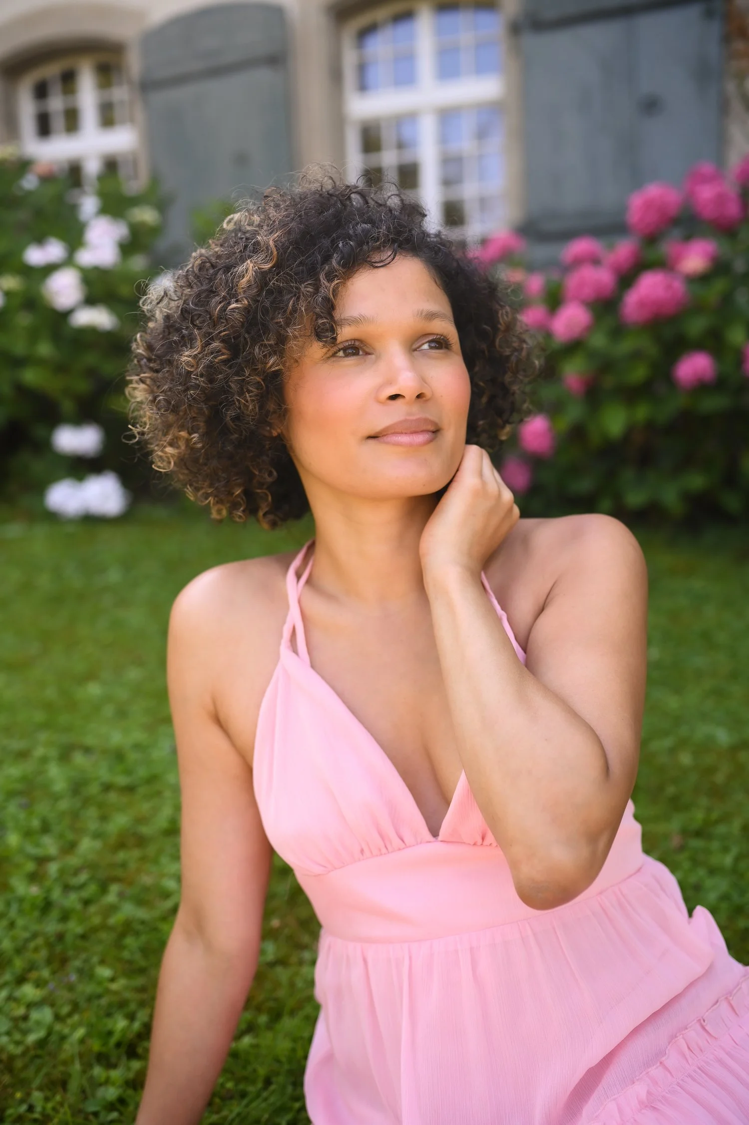Curly-haired woman in a rose dress
