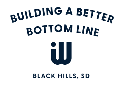 Text reading 'Building a Better Bottom Line, Black Hills, SD' with a logo consisting of interconnected 'W' shapes.