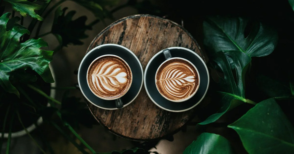 To coffees on a table to represent having a chat with a charity branding agency.