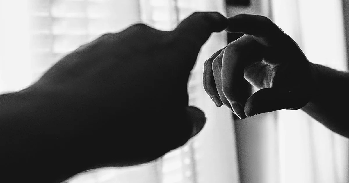 Two hands touching to represent reviewing every touchpoint of your charity brand.