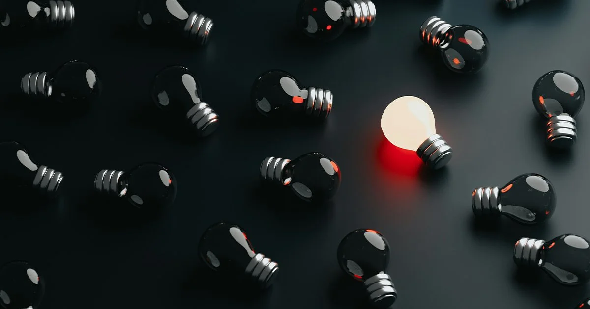 A lit lightbulb among unlit lightbulbs to represent brand differentiation for charities.