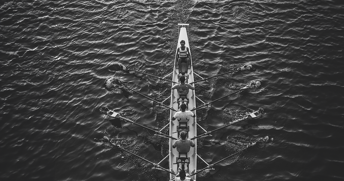 A team of rowers rowing on a river.