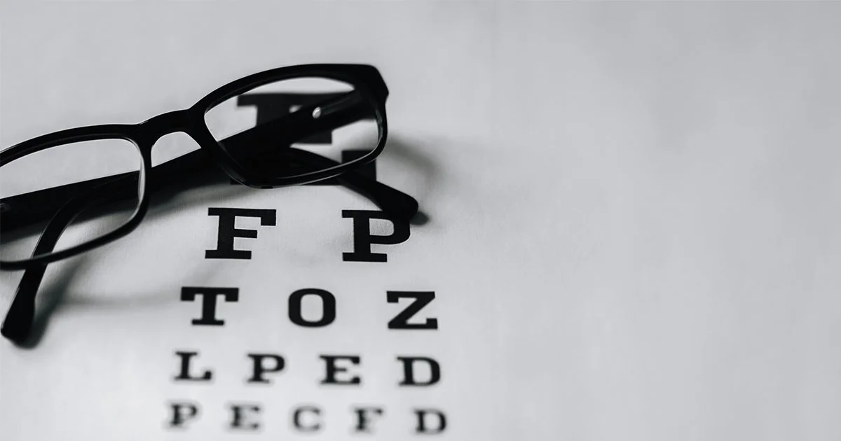 A pair of glasses and eye test card to represent bringing a charity branding vision to life.