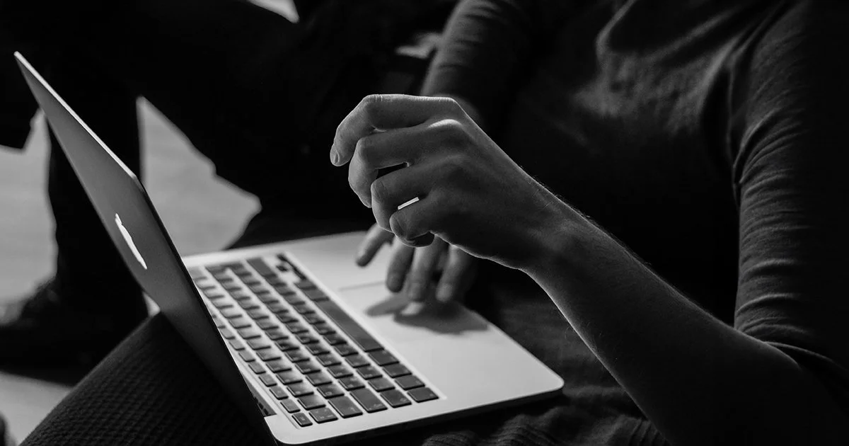 A woman on a laptop to represent making an impact online with charity brand.