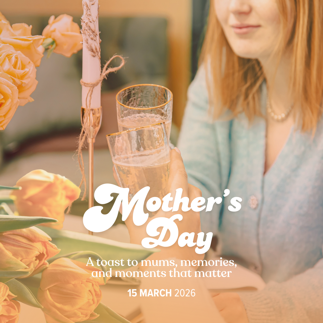 A woman raising a glass of champagne or sparkling wine in a toast at a Mother's Day celebration, with a floral centerpiece featuring pink roses and a candle in the background, and text overlay that reads 'Mother's Day: A toast to mums, memories, and moments that matter, 15 March 2026.'