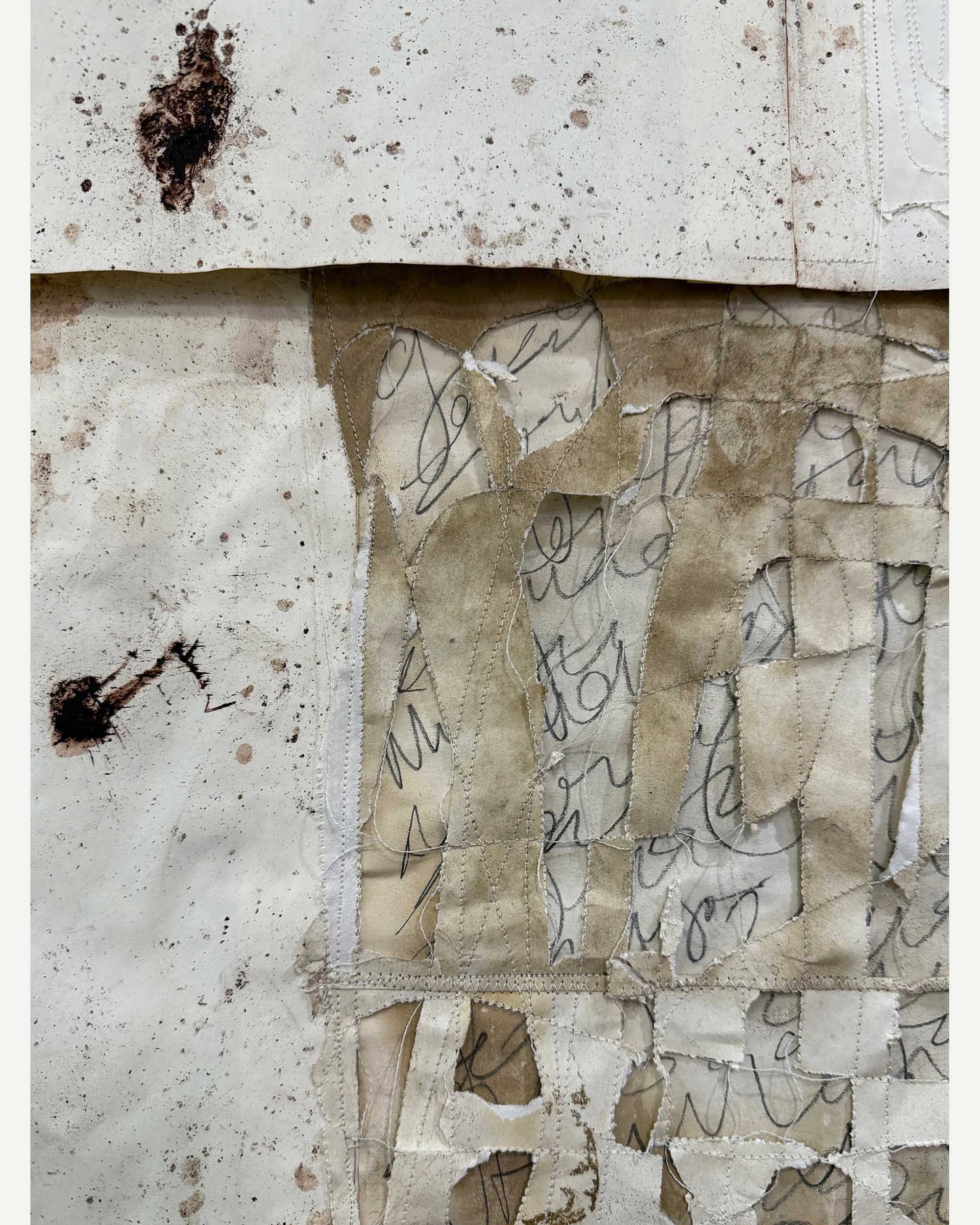 Close-up of torn and stained paper with handwritten cursive text, layered with burned patches and dirt stains.