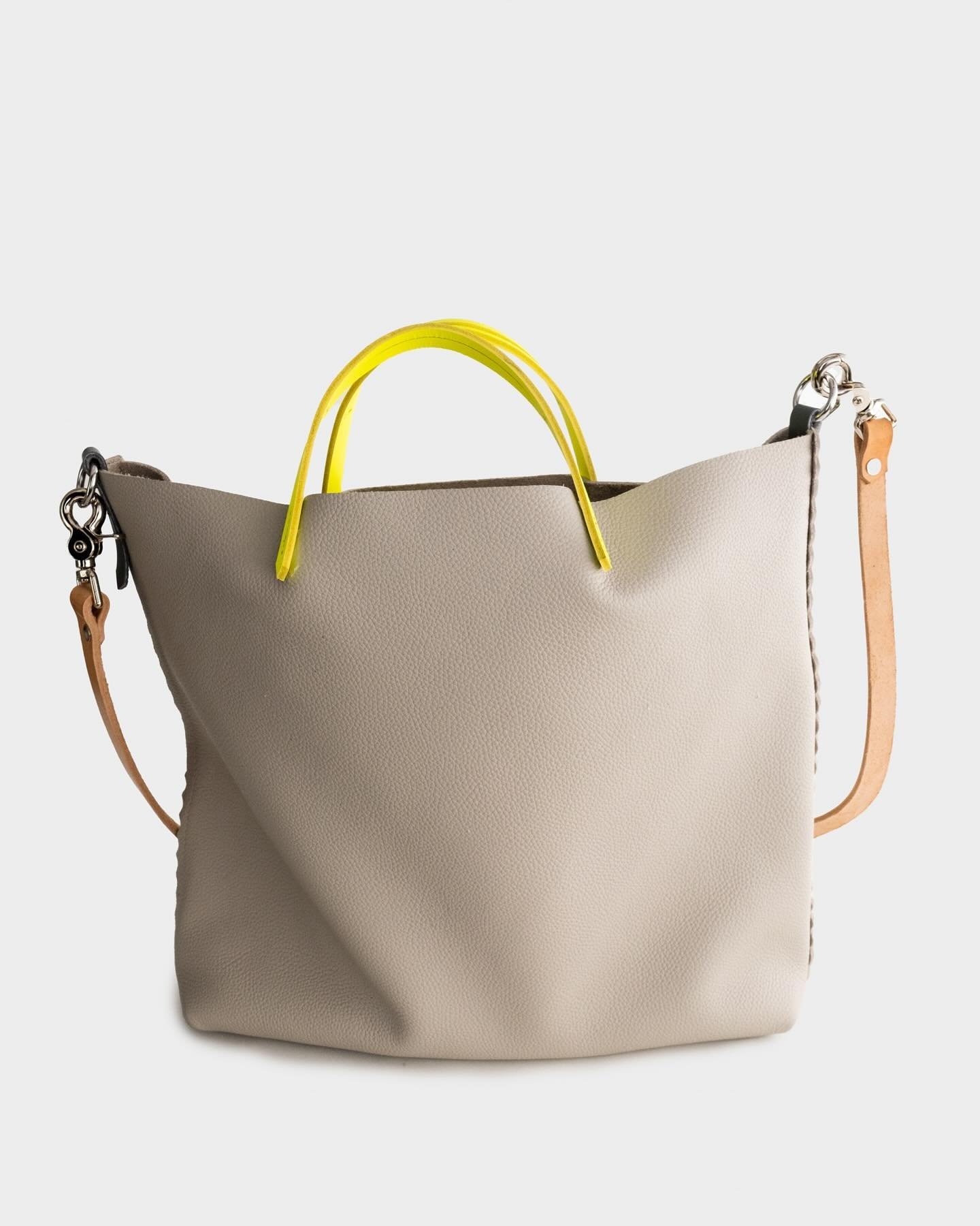 Not too light, not too dark- 
Light grey is the Goldilocks of hues. 
Limited edition, Italian milled Louche Tote in dove grey with neon leather handles is available on the website ⬆️
.
Booking Spring Trunk shows now! DM to enquire 💥
.
.
#trunkshows 