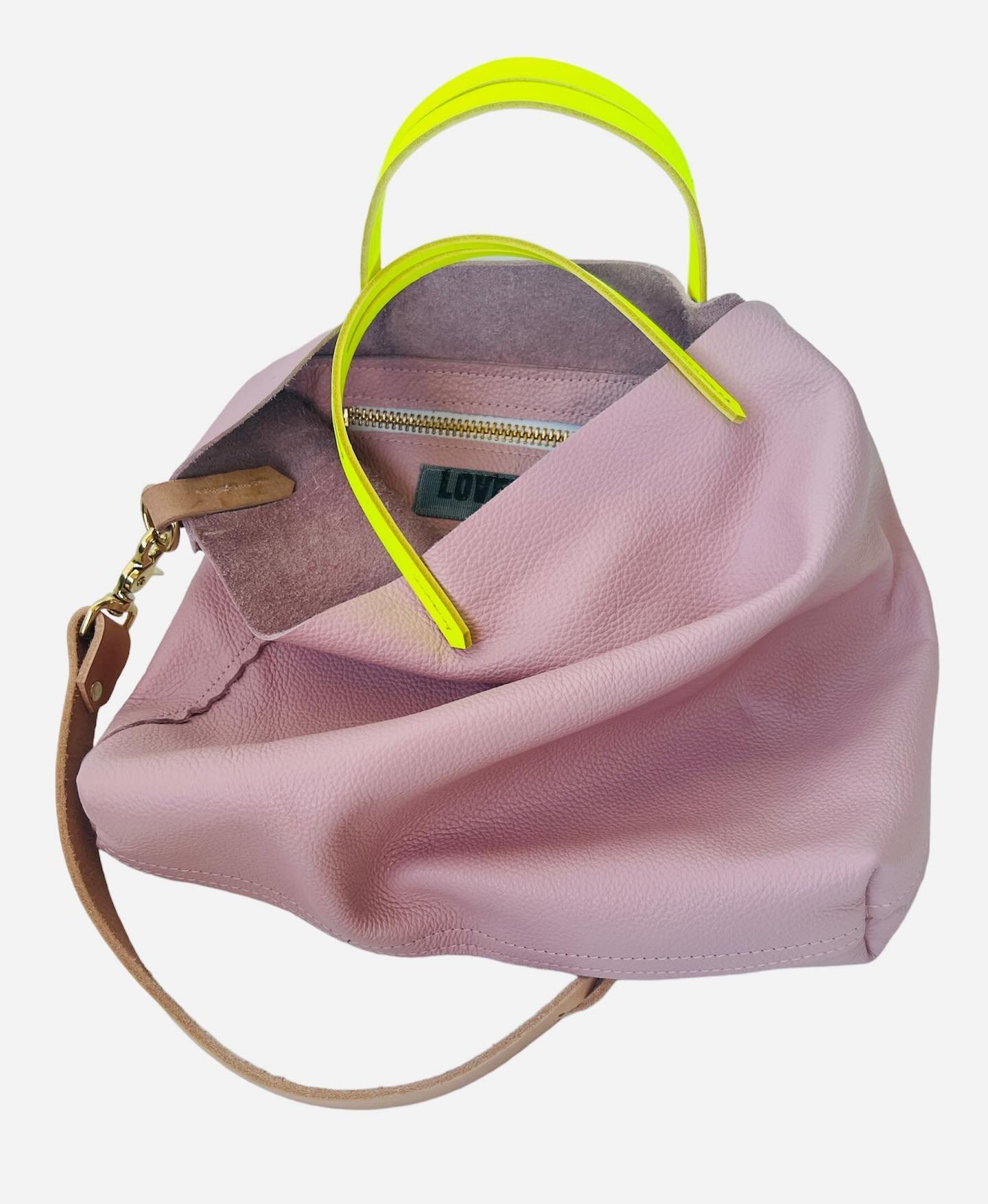 My mom always told me to dare to be different, and now I&rsquo;m asking the same of you.
.
Petal pink milled leather from Italy with neon leather handles and your choice of shoulder strap- consider this a triple-dog dare for next-level confident cool