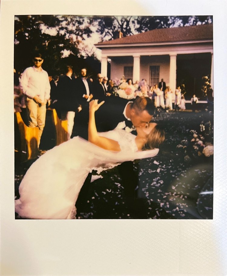 Polaroid of a bride and groom kissing at their reception
