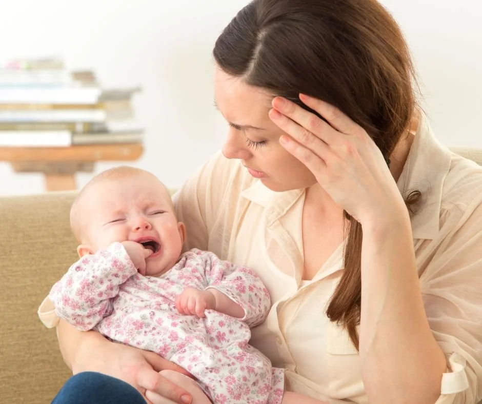 Upset baby being held by mum during a difficult settling moment
