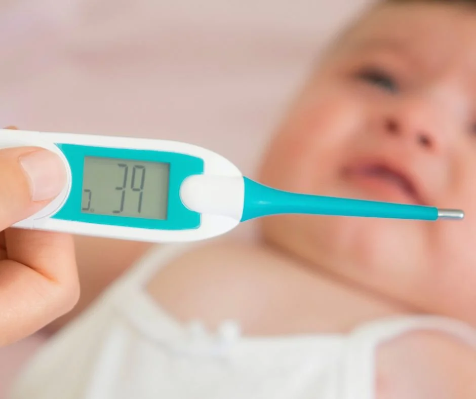 Parent checking a baby's temperature with a thermometer, as a fever is not caused by teething