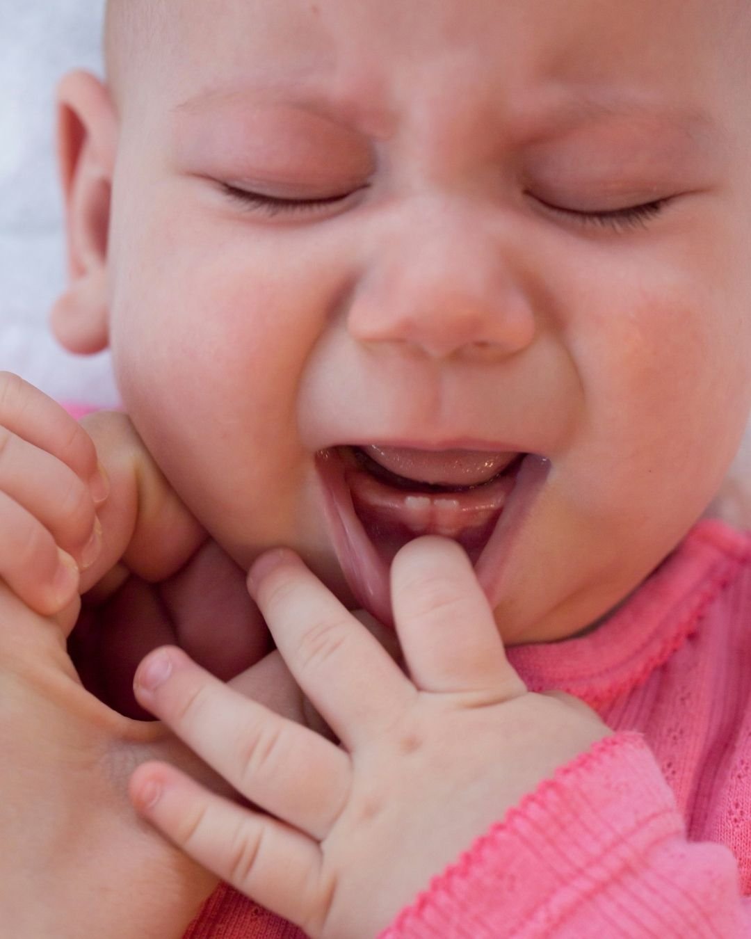 Baby crying and dribbling while teething, a common reason for unsettled sleep