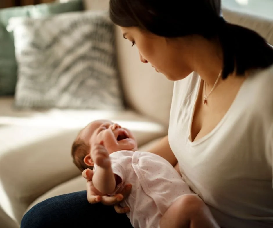 Baby crying in mum's arms showing signs of nervous system dysregulation