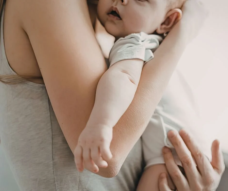 Mum holding her sleeping baby during a peaceful contact nap