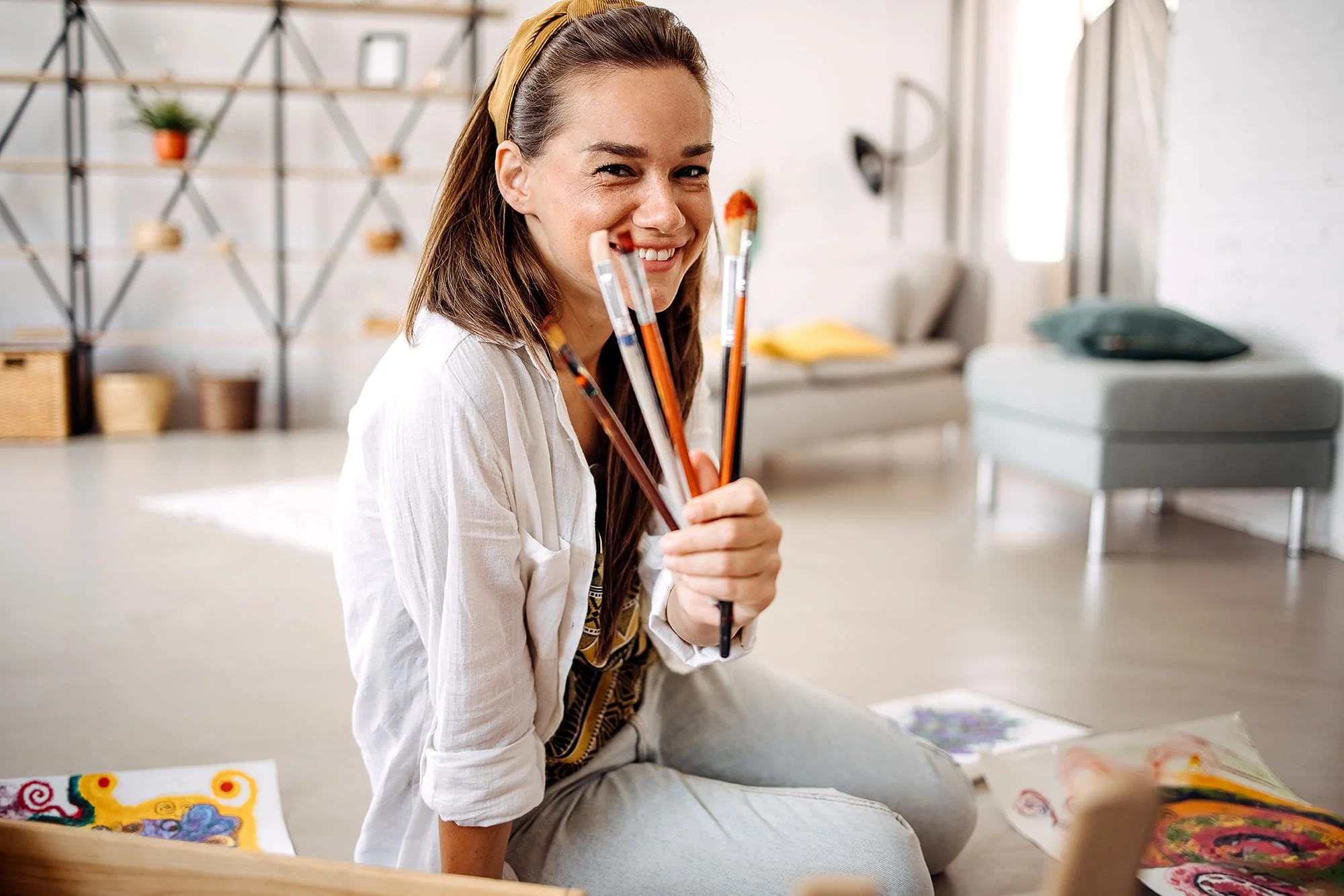 Frau malt mit Pinseln – kreativer Ausdruck und intuitives Malen im Kreativworkshop für Frauen