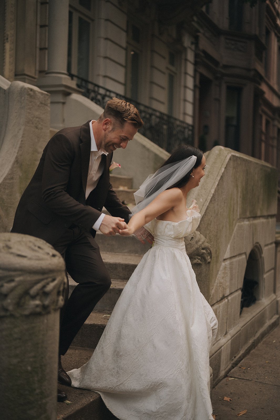 Bride and groom walking down steps in Manhattan after their Cakewalk elopement ceremony.