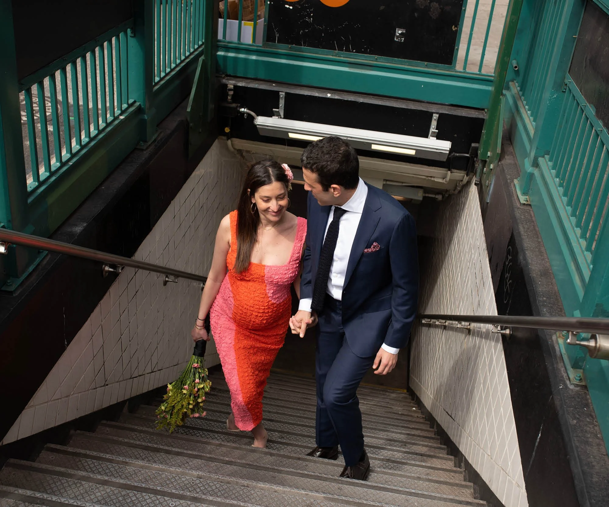 Eloping couple walking out of the subway on their way to their tiny wedding in Freeman Alley, Manhattan  with the help of NYC wedding planner before their NYC wedding reception.