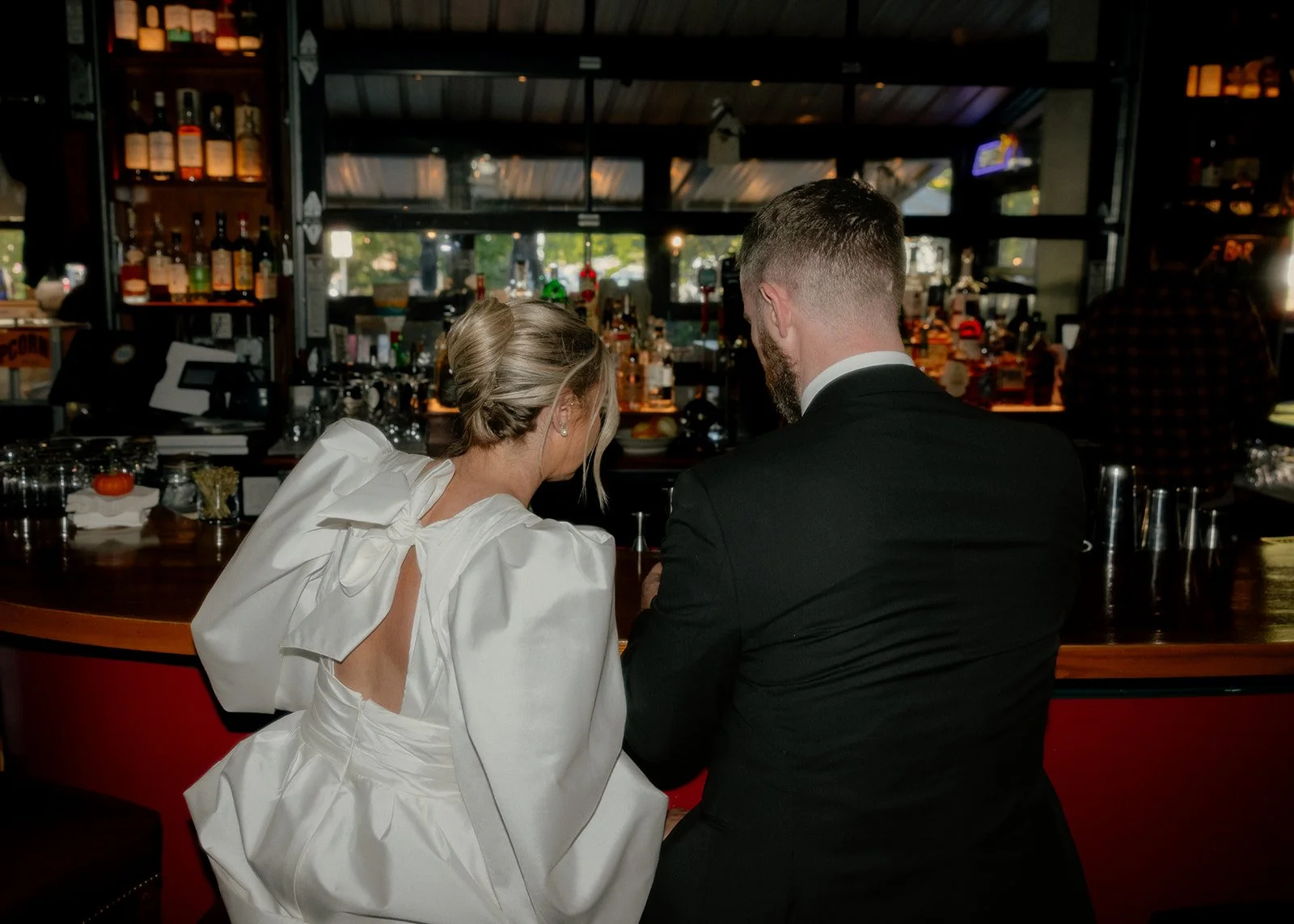 Bride and groom sitting at bar sharing drinks after their Cakewalk elopement.