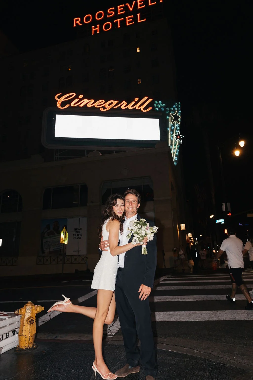 Couple posing in front of the Roosevelt Hotel in Hollywood after their Cakewalk elopement.