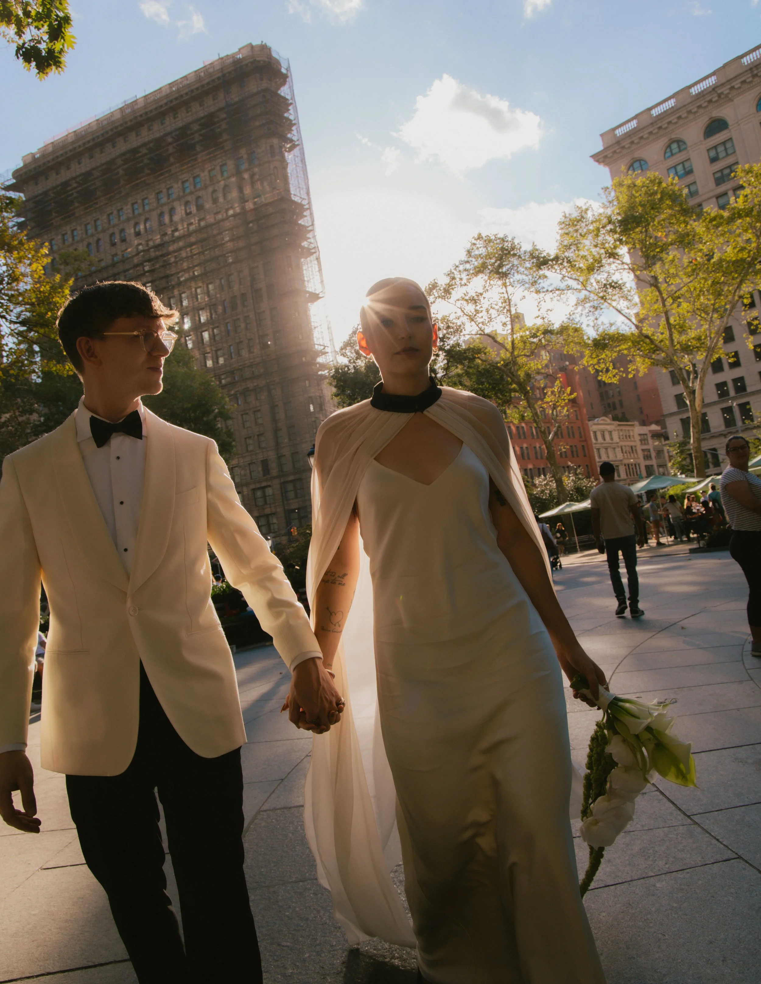 Bride and groom walking through Manhattan with the sun shining behind them after their Cakewalk elopement ceremony.