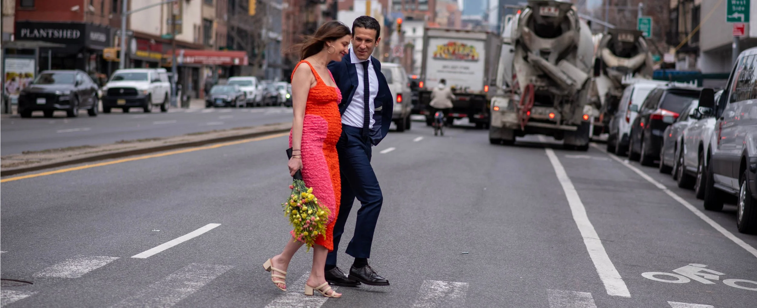 Eloping walk down busy street on the Lower East Side before their tiny wedding ceremony in Freeman Alley, Manhattan with the help of NYC wedding planner before their NYC wedding reception.