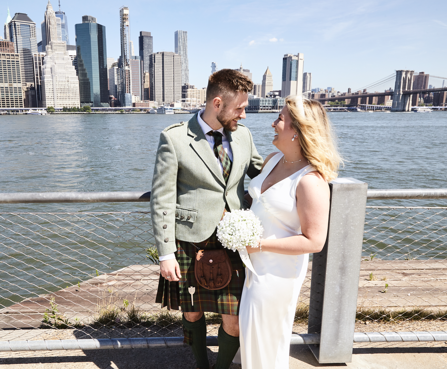 Scottish couple who eloped in Brooklyn on the waterfront overlooking the Manhattan skyline celebrates after their wedding ceremony.