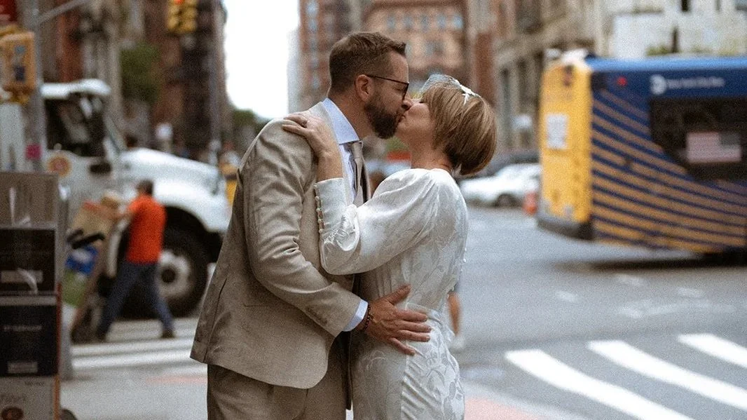 Documentary style photo of couple kissing at a NYC crosswalk after getting married in an elopement style wedding with Cakewalk.
