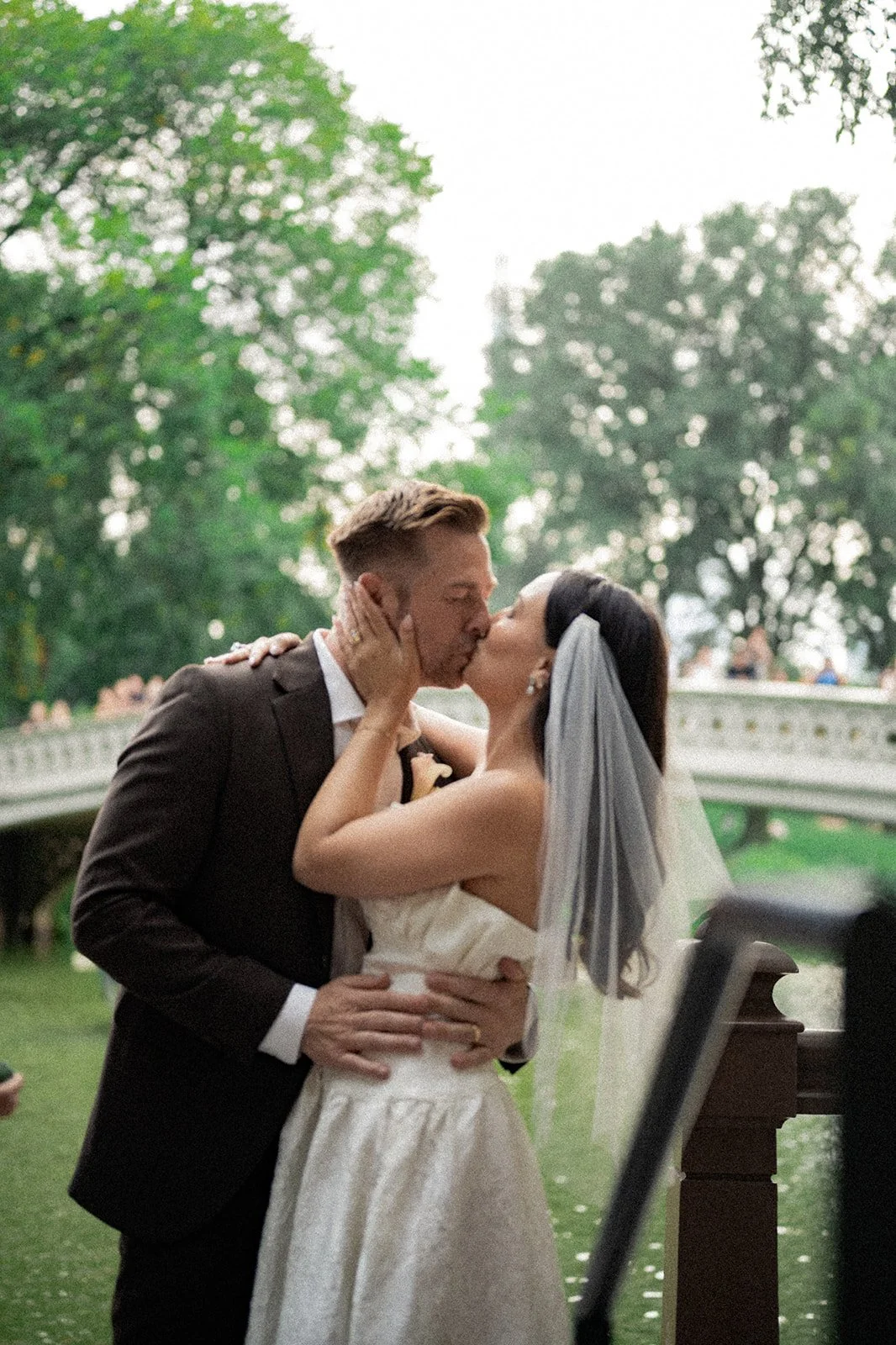 Newly married couple sharing their first kiss during a Central Park elopement at Bow Bridge