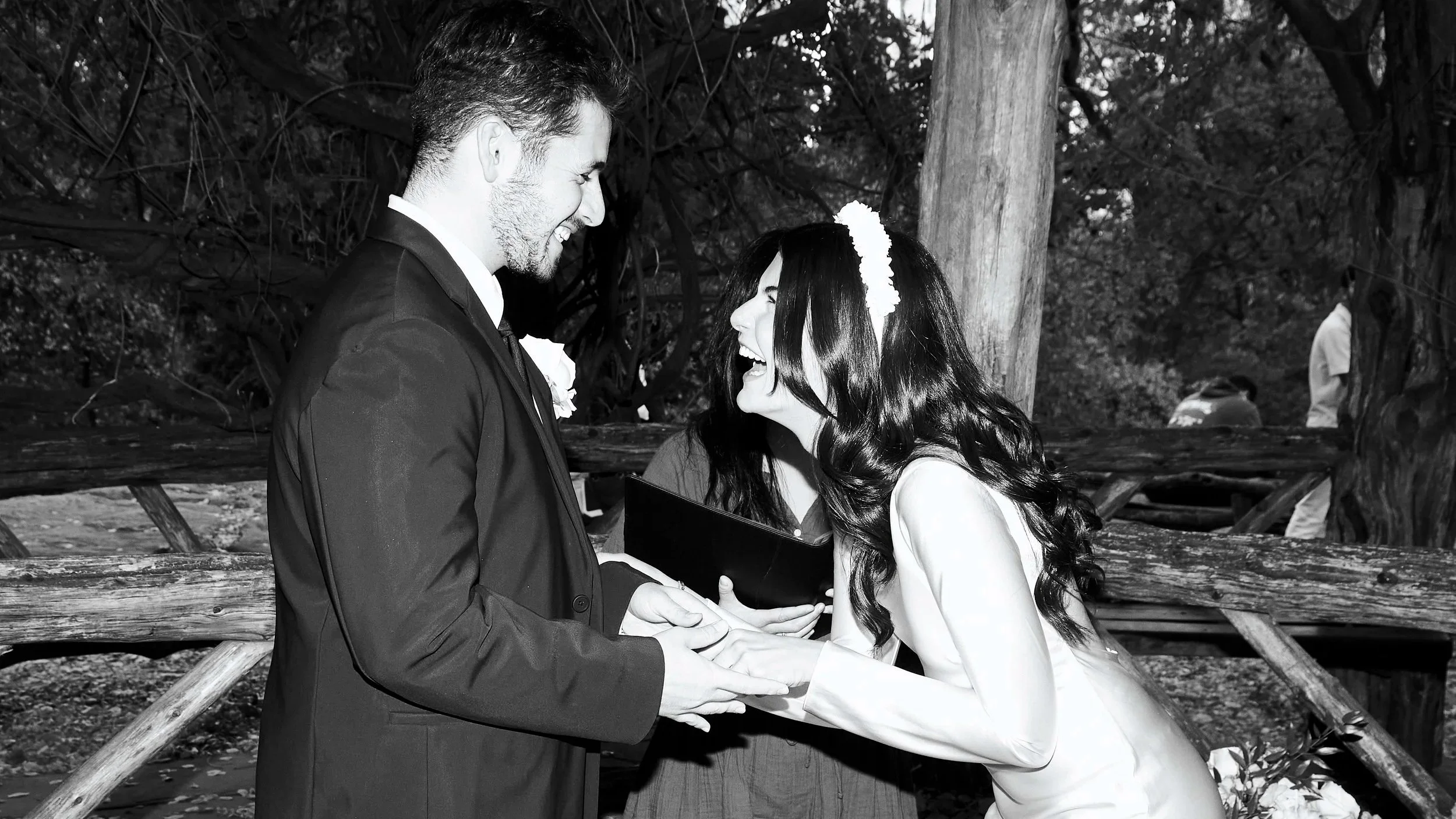 Sharifa and Jafar holding hands during their Cop Cot Central Park wedding, with Sharifa's sister Alia behind them.