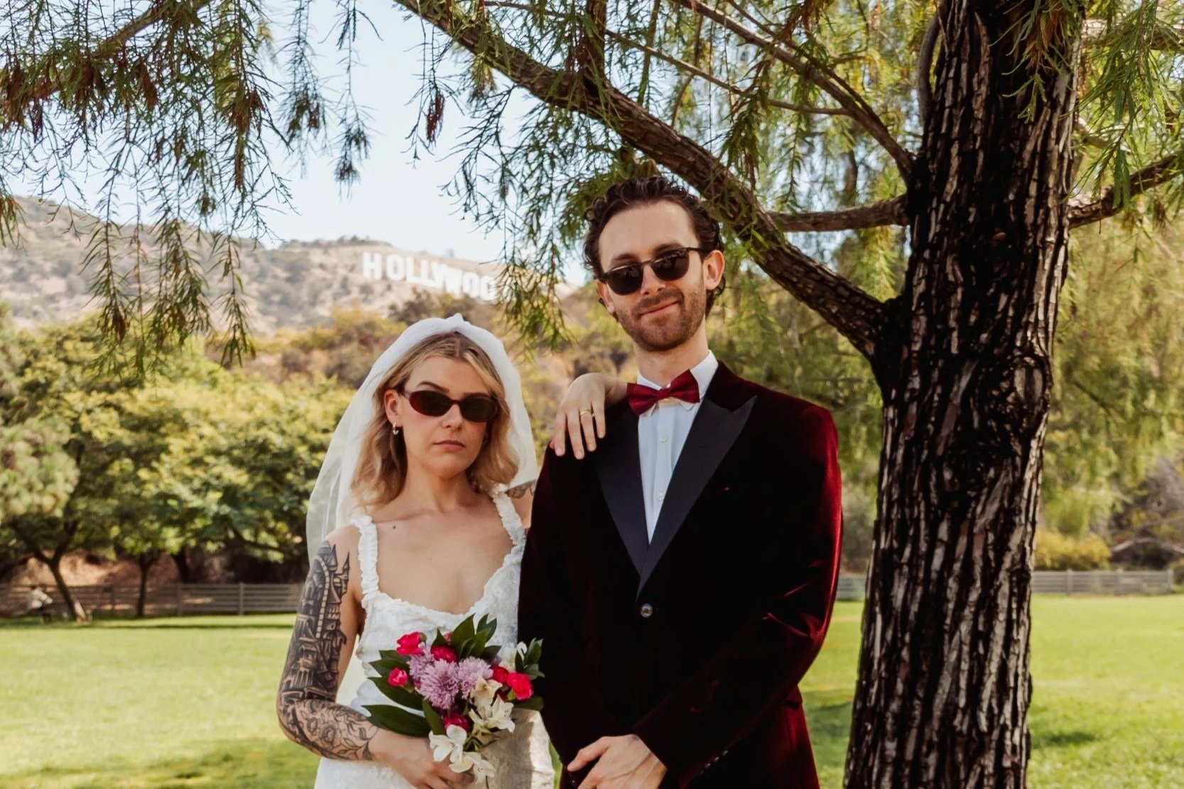Emma and Adam beneath a tree at Lake Hollywood Park with the Hollywood Sign behind them.