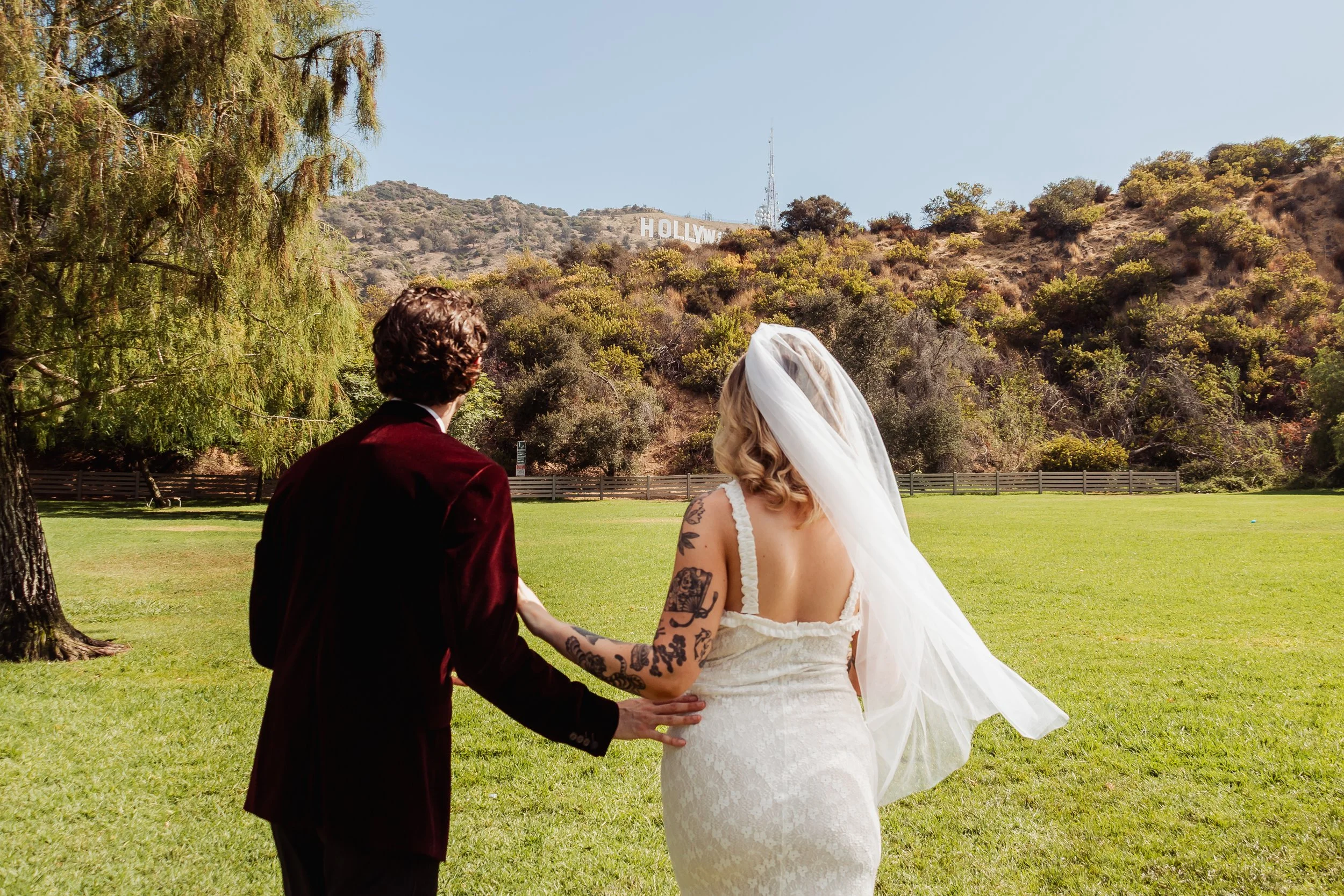 Couple celebrating their Cakewalk elopement at the Hollywood Sign view in Lake Hollywood Park.