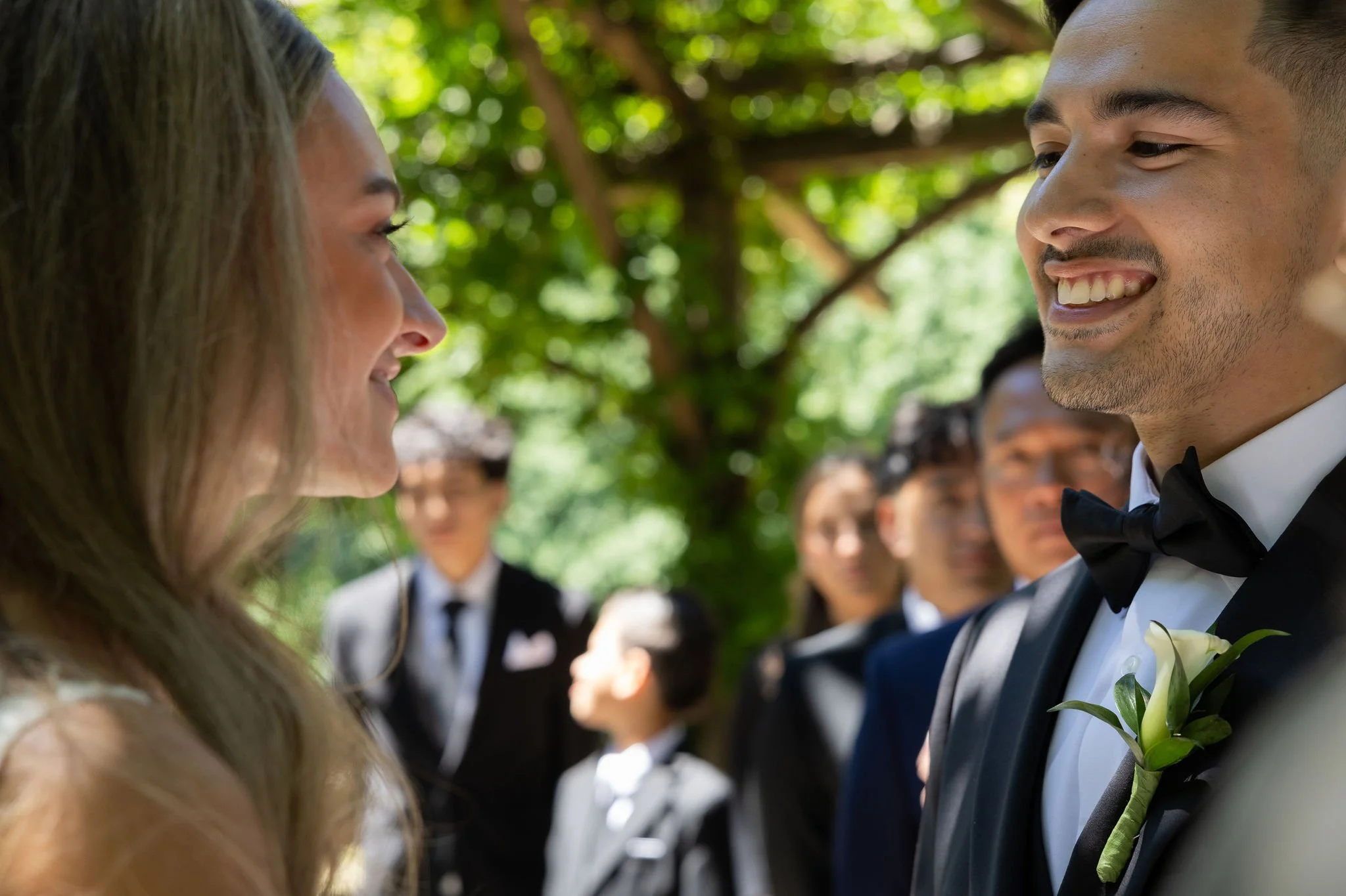 Bride and groom smiling during their wedding ceremony at Cop Cot in Central Park.