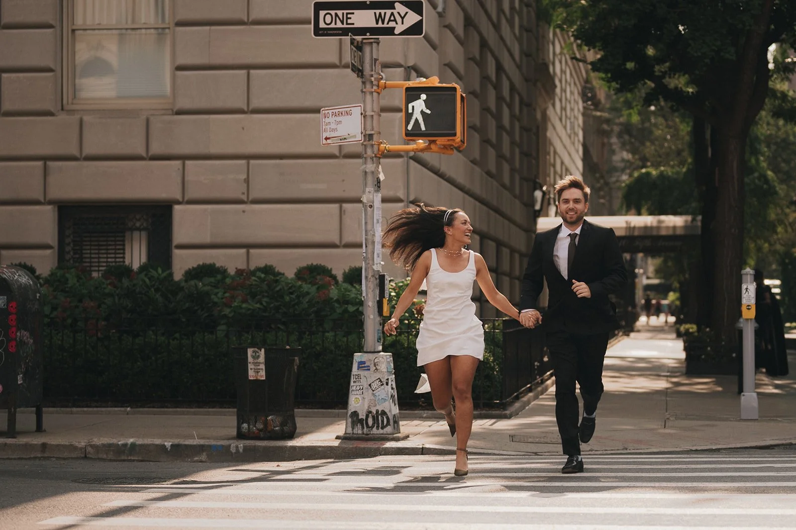 Bride and groom running across the street in Manhattan on the way to their Cakewalk elopement ceremony.