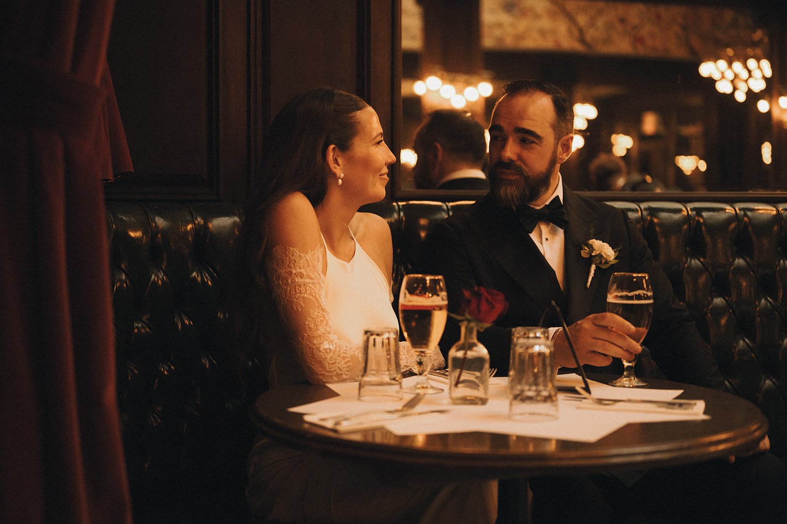Bride and groom seated for drinks at a Fifth Avenue bar after their Cakewalk elopement.