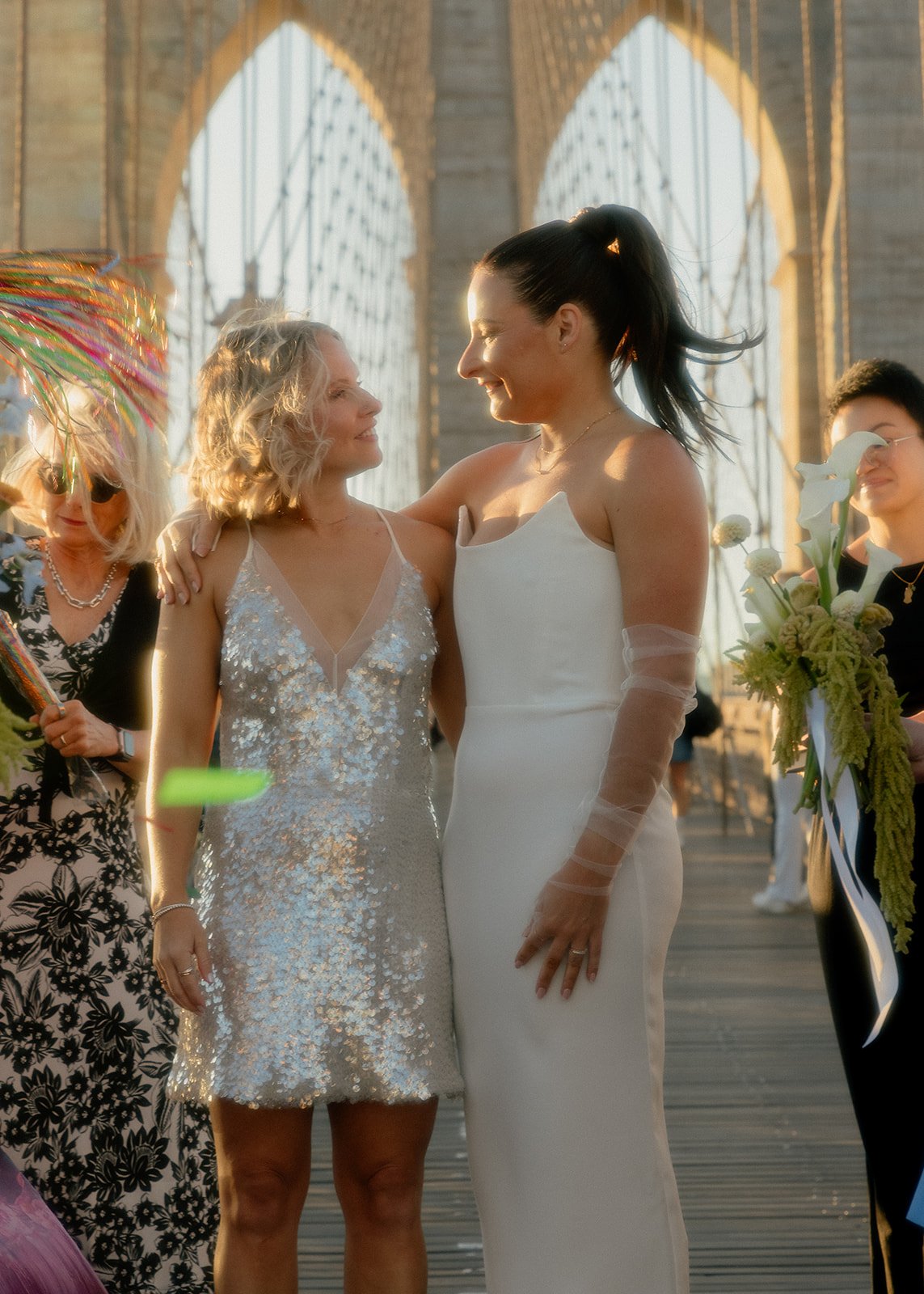 LGBT Couple from Australia looks into each other's eyes on the Brooklyn Bridge after their wedding ceremony with Cakewalk documented with editorial photography.
