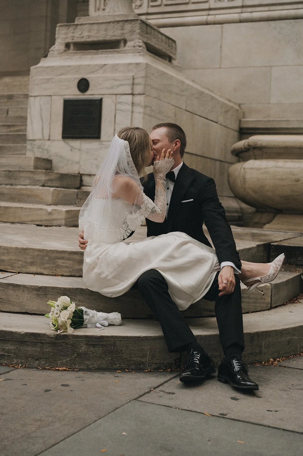 Married couple sitting on the steps of New York Public Library after their Cakewalk elopement.