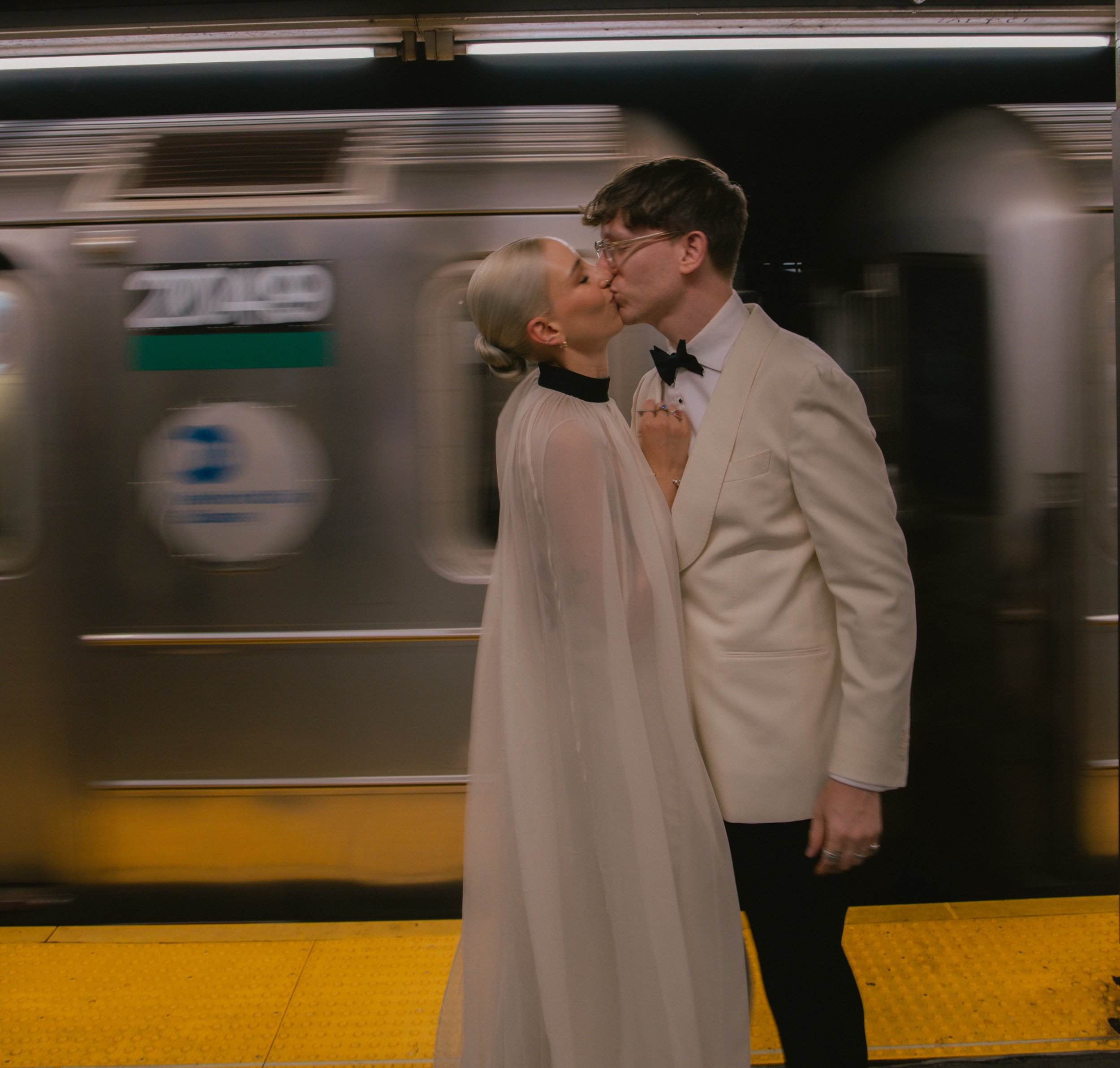 Couple kissing on a NYC subway platform during their Cakewalk elopement