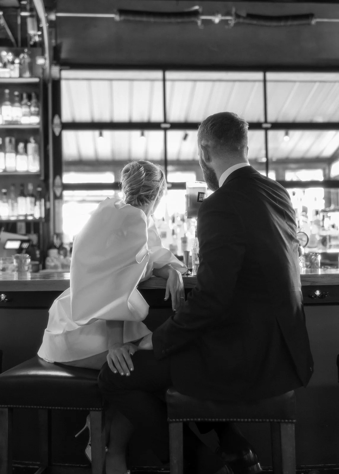 Bride and groom sitting at bar sharing drinks after their Cakewalk elopement.