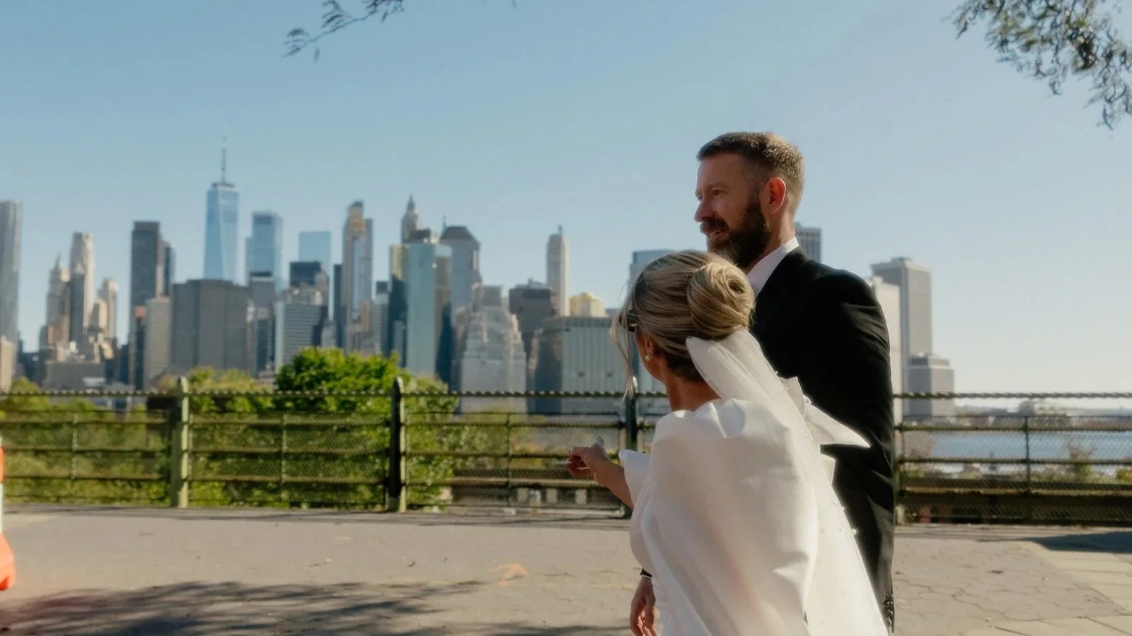 Couple on their wedding day with the Manhattan skyline in the background during a Brooklyn waterfront elopement