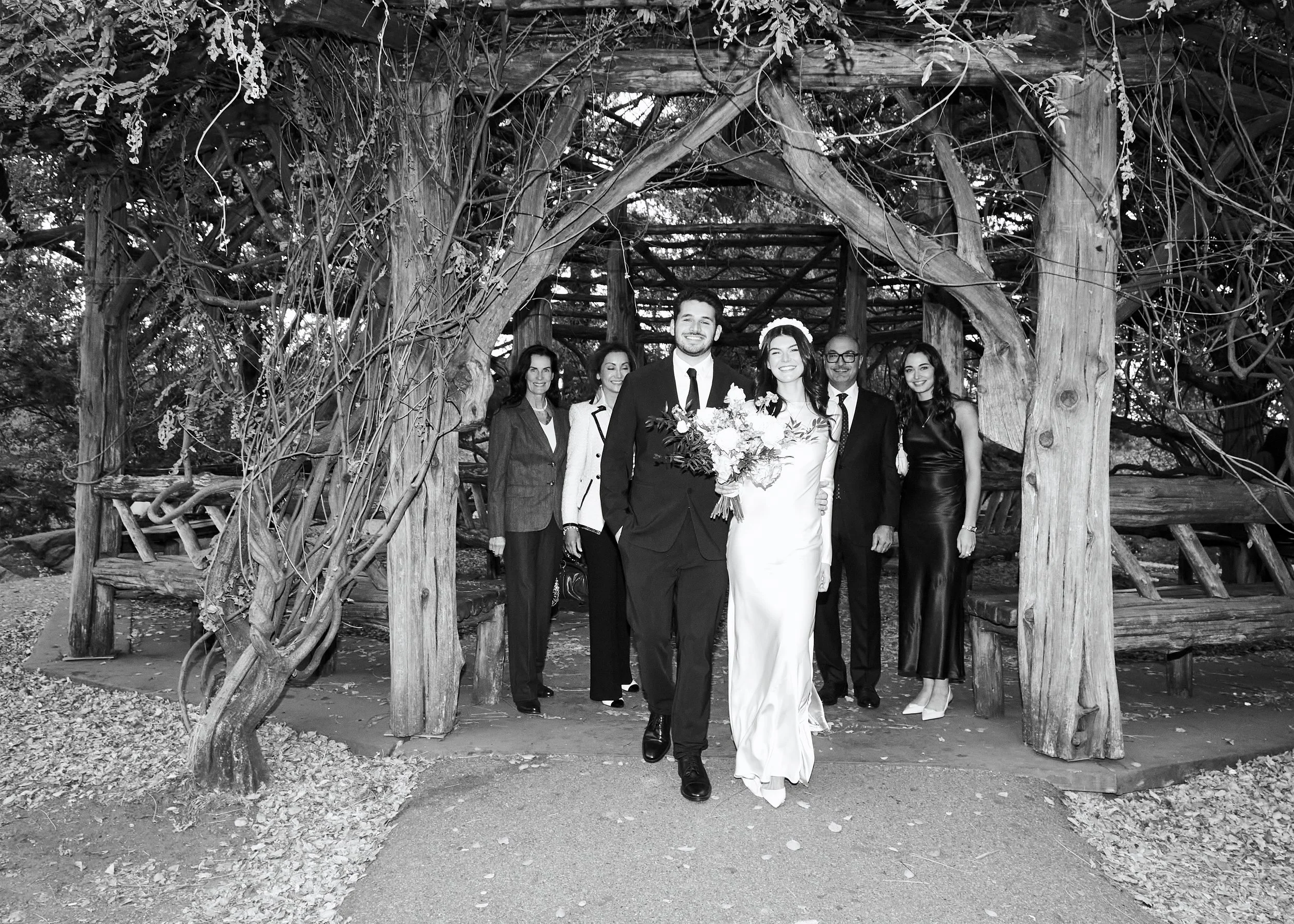 Couple walking out of Cop Cot after their Central Park elopement ceremony with family