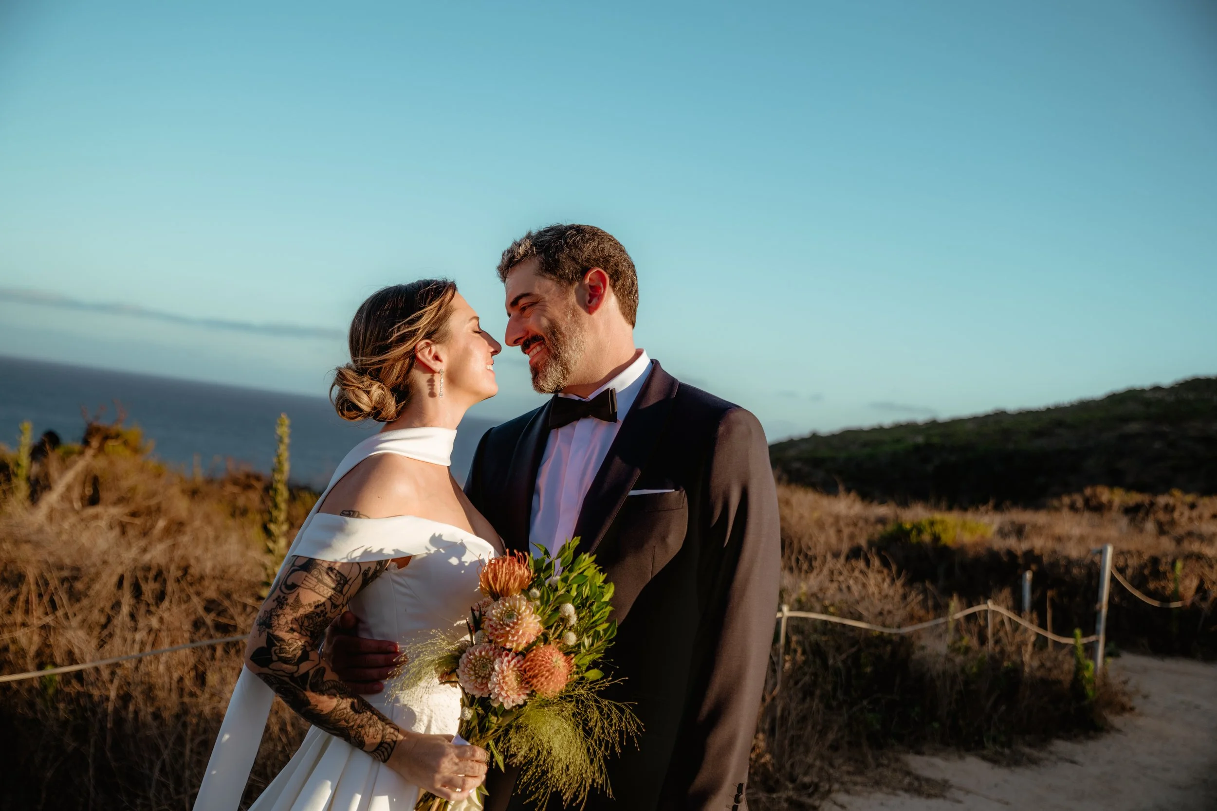Bride and groom smiling at Point Dume near their Zuma Beach micro wedding.