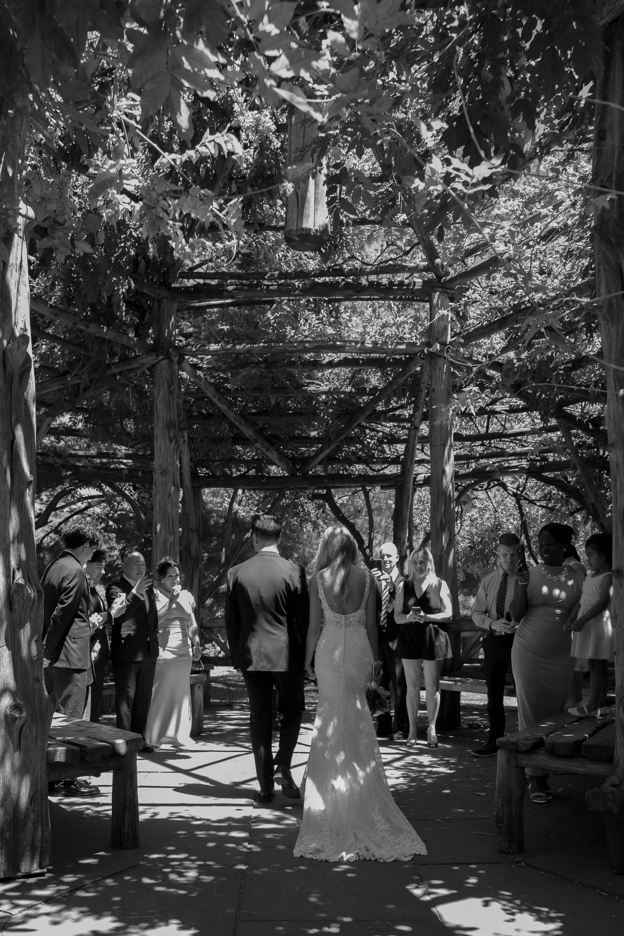 Documentary style photo of couple getting married with guests at Cop Cot in Central Park in the spring.