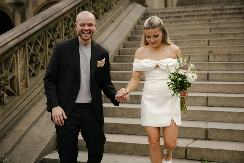 Bride and groom walking down a staircase in Central Park, on the way to their Cakewalk elopement.