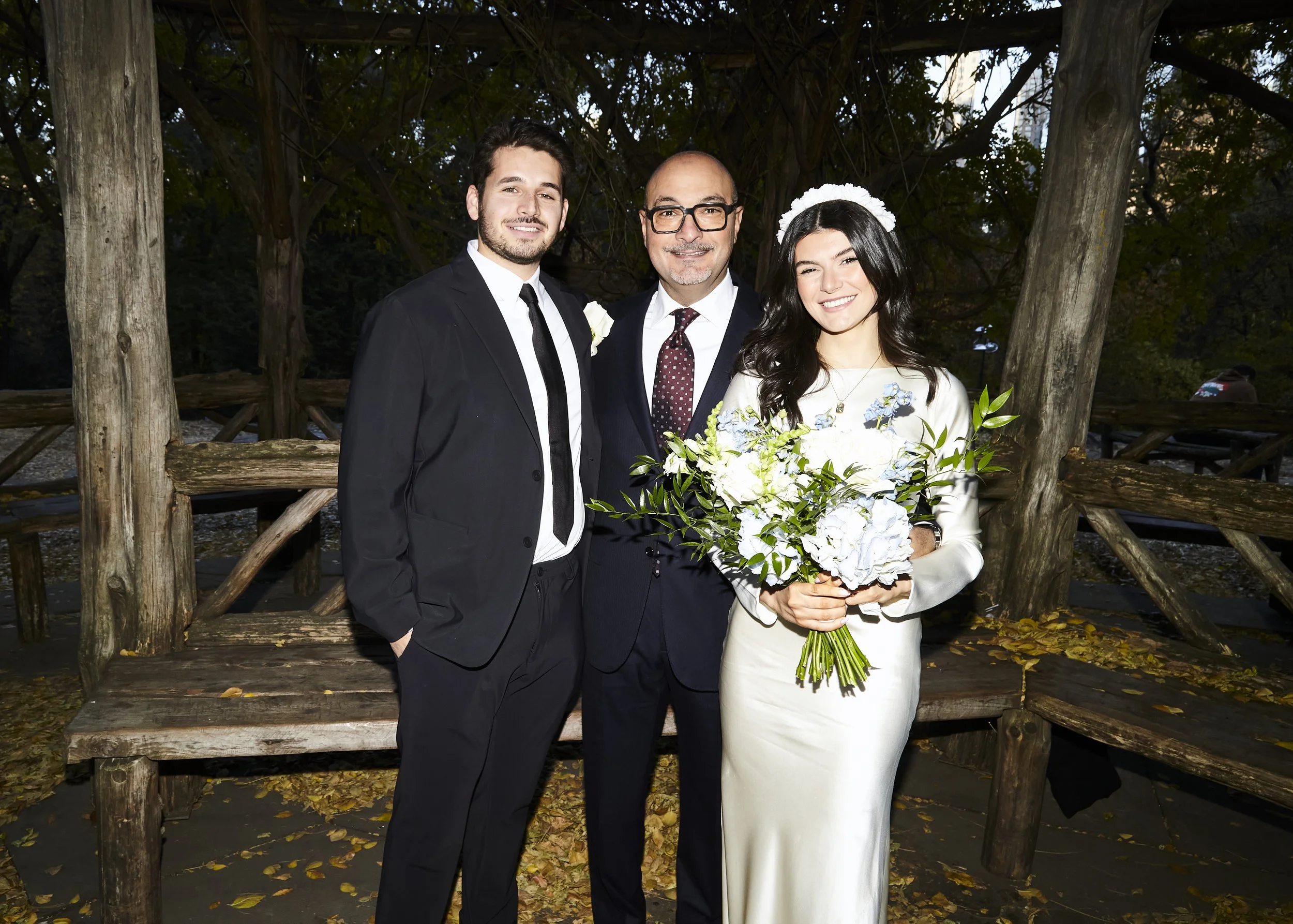 Bride, groom, and father standing under the Cop Cot gazebo in Central Park, after their Cakewalk micro wedding.