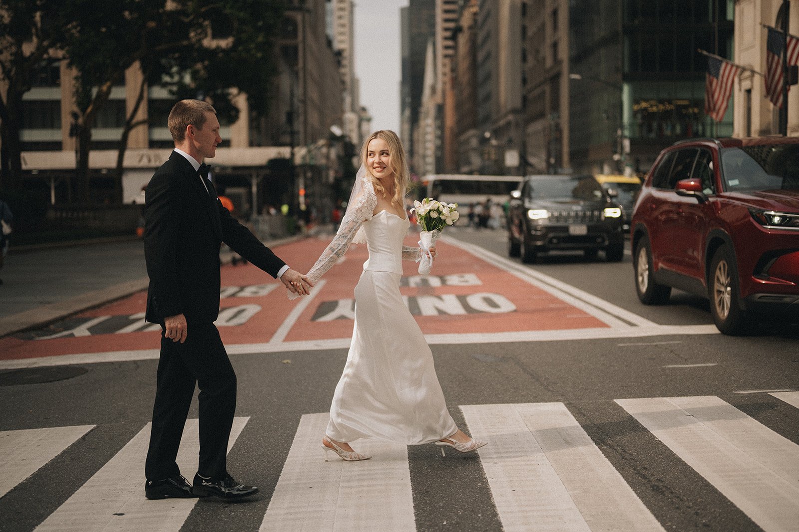 Couple crossing a busy street in a wedding gown and tuxedo during their Cakewalk elopement.