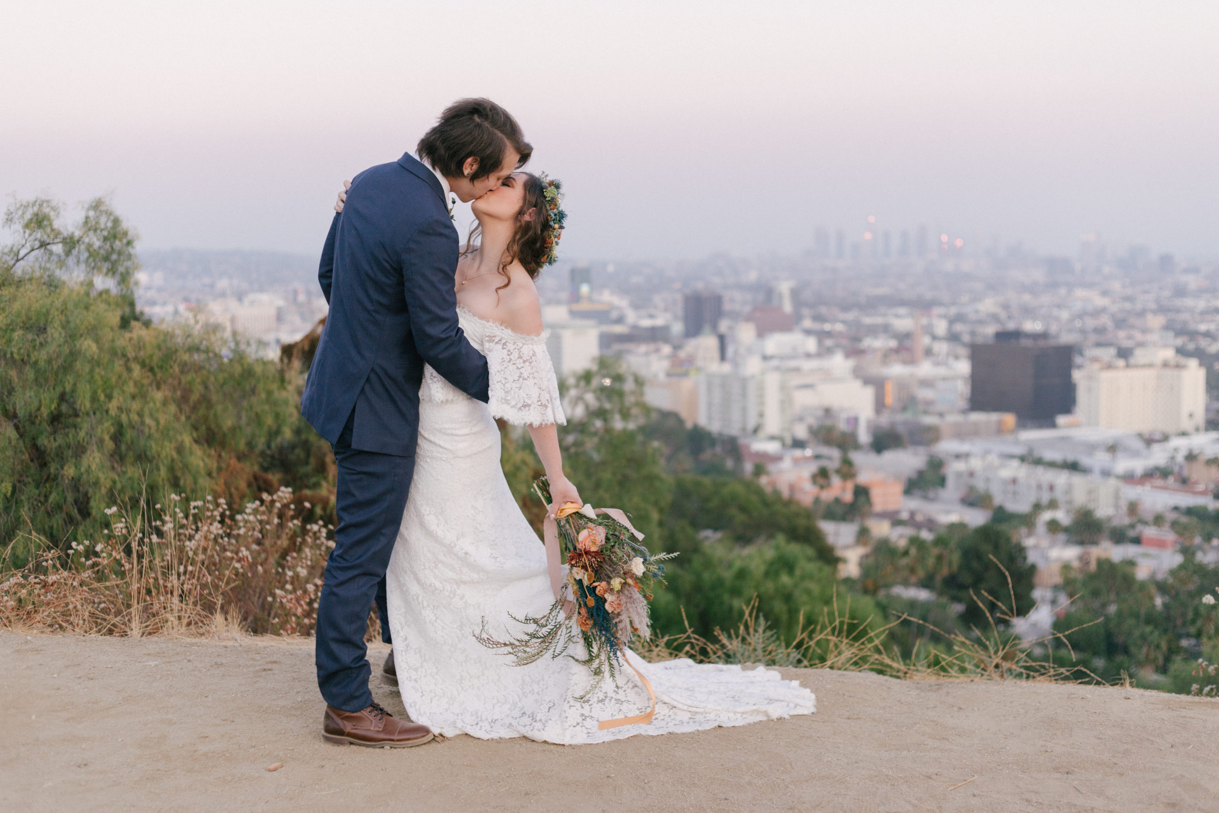 Couple kissing on a hill over the LA skyline at sunset