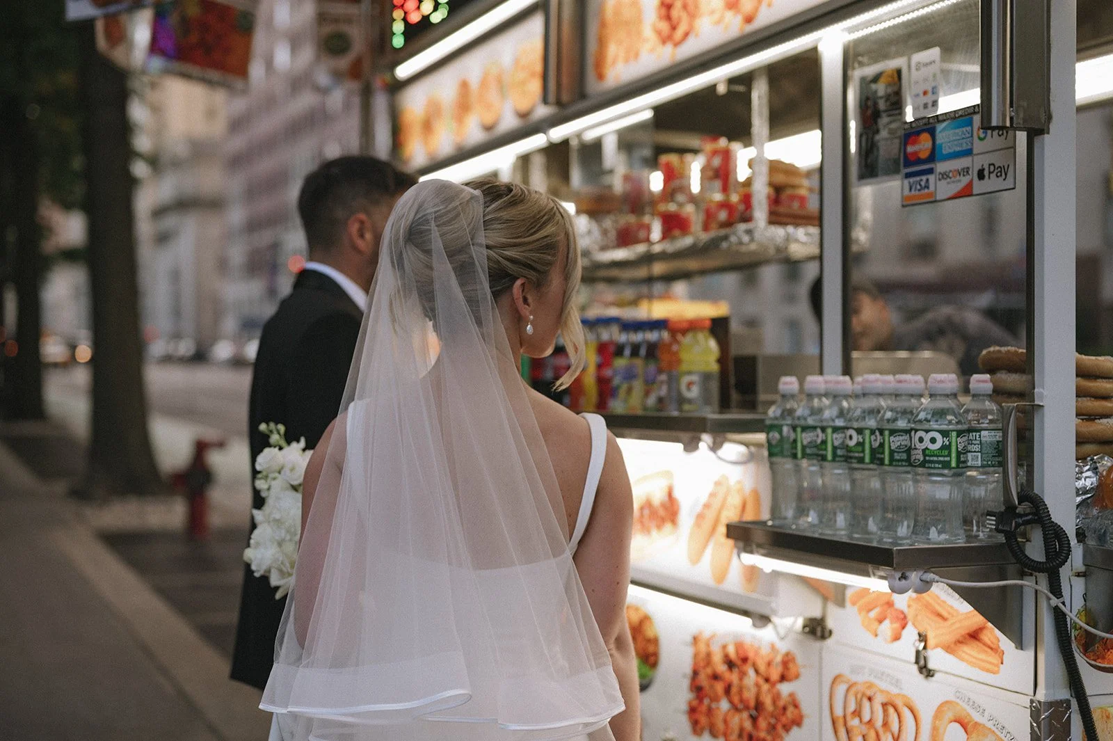 Bride and groom ordering a snack at a Manhattan, NYC food truck after their Cakewalk micro wedding.